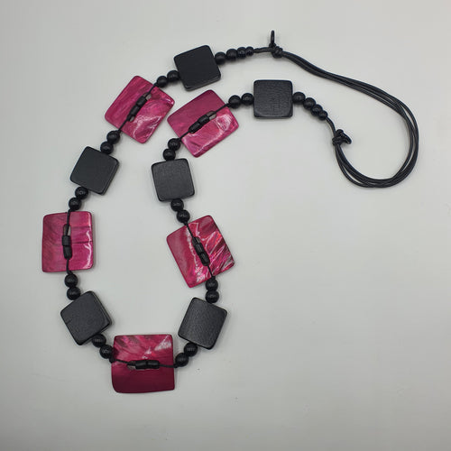 Collana lunga in legno nero e madreperla fuxia.