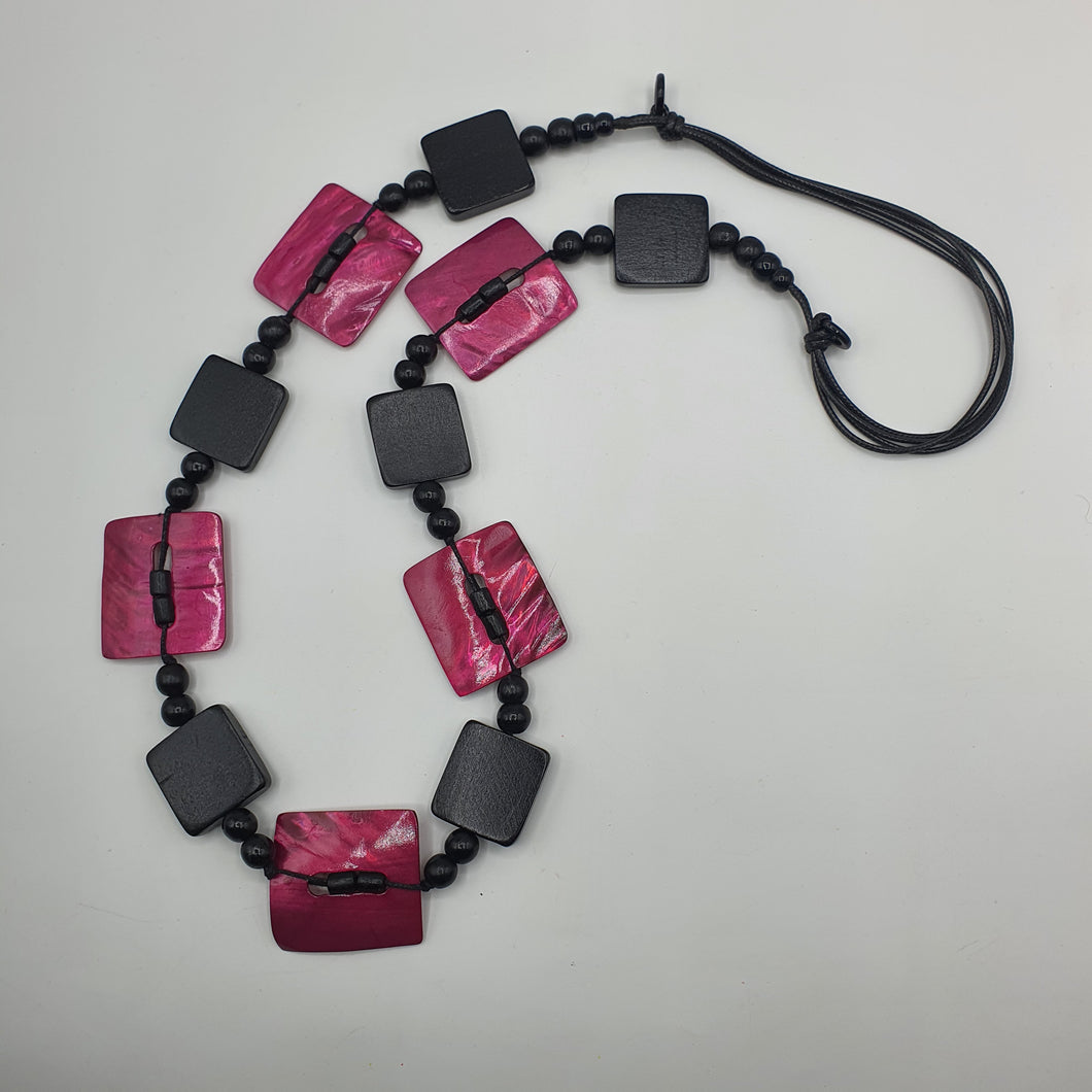 Collana lunga in legno nero e madreperla fuxia.