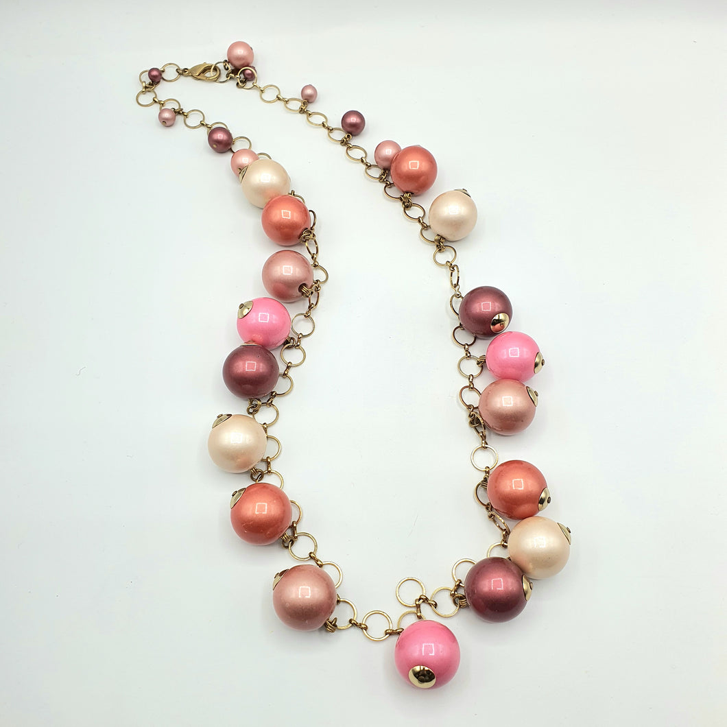 Collana perle rosa pendenti montate su catena placcata oro.